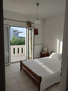 een slaapkamer met een bed en een groot raam bij Kassandra Garden Residence in Istron