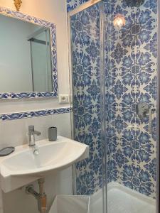 y baño con lavabo y ducha con azulejos azules y blancos. en B & B La casa dei sogni, en Casapulla