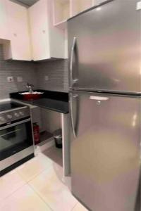 a kitchen with a stainless steel refrigerator and a sink at داماك الكورنيش جدة الجناح الذهبي Damac tower jeddah in Jeddah
