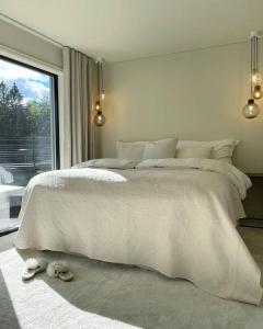 1 dormitorio con cama blanca y ventana en Lekkert rekkehus med peis, en Hektner