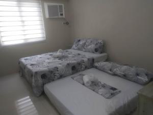 a room with three beds and a window at Sunvida Tower Across SM City Cebu in Cebu City +27 photos