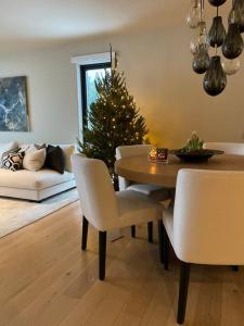 a dining room with a christmas tree and a table and chairs at Lekkert rekkehus med peis in Hektner