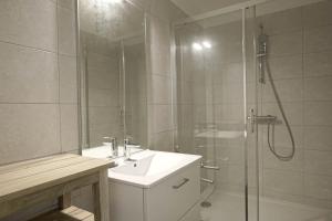 ein Bad mit einem Waschbecken und einer Dusche in der Unterkunft Gold Beach Studio in Tracy-sur-Mer