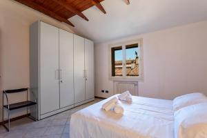- une chambre blanche avec un lit et une fenêtre dans l'établissement Bologna's Way Sguardo sui Tetti, à Bologne