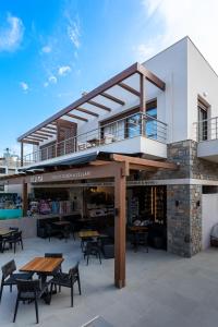 a building with a deck with tables and chairs at La Vista Azul - Sea View Apartment in Pláka