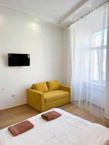 リヴィウにあるSoVA Apart вулиця Вірменськаのベッドルーム(ベッド1台、黄色のソファ付)