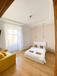 リヴィウにあるSoVA Apart вулиця Вірменськаのベッドルーム(白いベッド1台、黄色のソファ付)