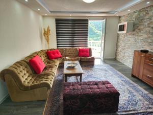 a living room with a brown couch and red pillows at Rooms Mery in Visoko