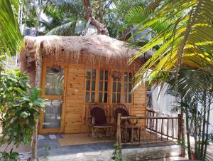 a small house with a thatch roof on a porch at Yoga Culture Palolem in Palolem