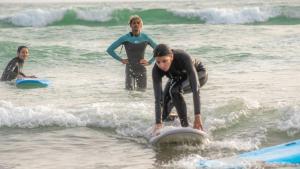 a group of people in the ocean on surfboards at Taghazout Roof Hostel in Taghazout