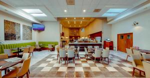 ケレタロにあるプラザ カメリナス ホテルのテーブルと椅子、ピアノのあるレストラン