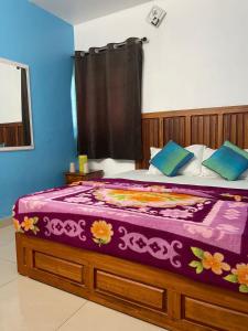 um quarto com uma cama grande e um cobertor roxo em Mountain cheers munnar em Munnar