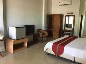 a bedroom with a bed and a television and a chair at Onthebeach resort in Ban Hin Sam Kon