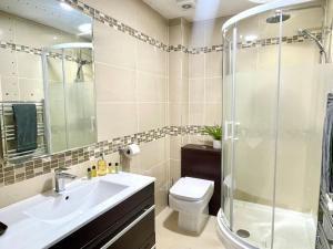 bagno con doccia, lavandino e servizi igienici di Apartment 3 Benllech with Sea views a Benllech