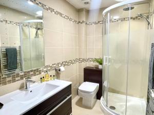 a bathroom with a shower and a sink and a toilet at Apartment 3 Benllech with Sea views in Benllech