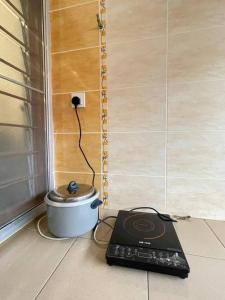 a scale sitting on the floor next to a pot at Cozy 119 Homestay Teluk Intan in Teluk Intan