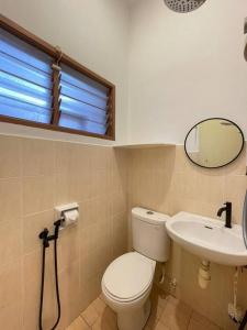 a bathroom with a toilet and a sink and a mirror at Cozy 119 Homestay Teluk Intan in Teluk Intan