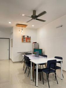 uma sala de jantar com uma mesa branca e cadeiras em Cozy 119 Homestay Teluk Intan em Teluk Intan