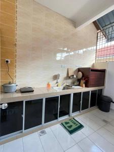 uma cozinha com um lavatório e uma bancada em Cozy 119 Homestay Teluk Intan em Teluk Intan