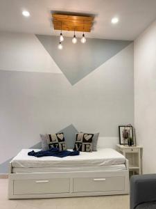 a bedroom with a bed with a white wall at Cozy 119 Homestay Teluk Intan in Teluk Intan