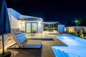 a villa with a swimming pool at night at Campo Premium Stay Private Pool Villas in Kos