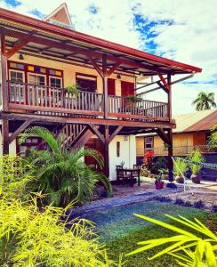 a house with a deck and a pool at Queen Maxima by Prins Hendrik Suites in Paramaribo