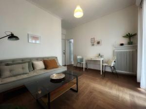 a living room with a couch and a table at Urban Retreat: 1-bedroom with terrace in Goudi in Athens