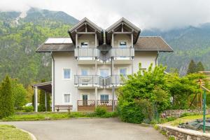 a large white house with a balcony on a mountain at Appartment Isabelle - Kamille in Presseggersee