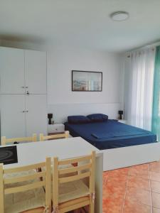 een slaapkamer met een bed en een tafel en stoelen bij Seaside Deluxe Apartment in Durrës