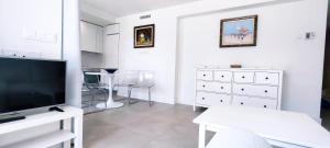 a white living room with a flat screen tv at Panorama Beach - Albatros Apartment in Torrox Costa