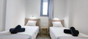 two twin beds in a room with two chairs at Panorama Beach - Albatros Apartment in Torrox Costa
