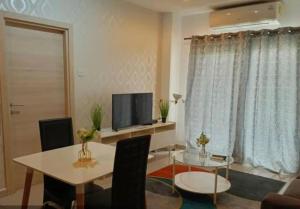 a living room with a table and a television at JaneChill Guest House in Accra