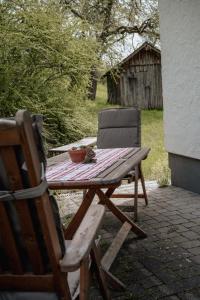 uma mesa de piquenique em madeira com uma cadeira e uma mesa em Ferienwohnungen Baumann-Breitenberg em Sankt Georgen am Reith