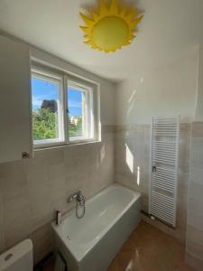 a bathroom with a tub and a window and a sink at Apartmán Na Polabí 2 in Mělník