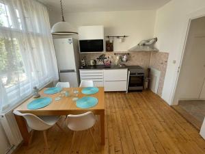 uma cozinha com uma mesa de madeira e cadeiras numa cozinha em Apartmán Na Polabí 2 em Mělník