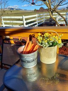 dos cubos de zanahorias y flores en una mesa en Applinger Farm en Ashland