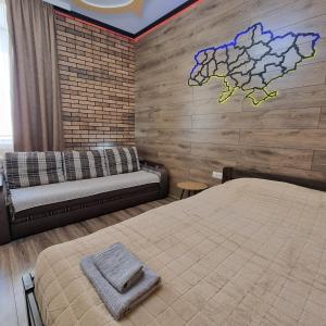 1 dormitorio con cama y sofá en Petropavlivska apartment, en Kamianets-Podilskyi