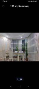 a picture of a dining room with a table and chairs at Таунхаус in Bishkek