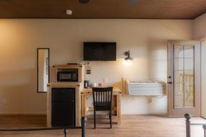 a room with a kitchen with a desk and a microwave at Miners Cabin #2 - King Bed - Accessible Room - Private Balcony in Tombstone