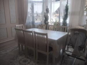 a dining room table and chairs with a table and chairsktop at Таунхаус in Bishkek