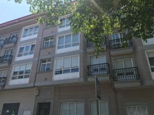 an apartment building with windows and balconies at Casa Nano in Sigüeiro