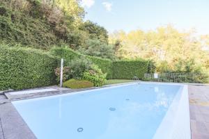 una piscina en un patio con un seto en Appartamento Terrenas, en Vercana