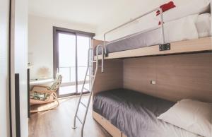 1 dormitorio con literas, silla y ventana en Appartamento Terrenas, en Vercana