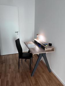 貝爾吉施格拉德巴赫的住宿－Moderne Wohnung mit Loggia - Neubau 2023，一张木桌、椅子和灯