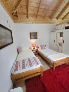 duas camas num quarto com um tapete vermelho em Xhumba Guesthouse 
