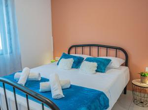 um quarto com uma cama com almofadas azuis e brancas em Doris home in Ilha de Rhodes