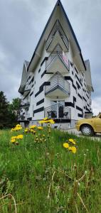 um edifício com um campo de flores à sua frente em Triangle studio 4 Divcibare em Divčibare