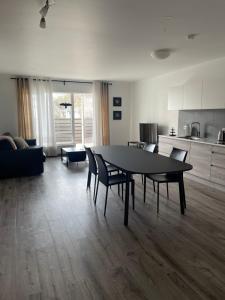 a living room with a table and chairs and a kitchen at Saga Apartments Reykjavík in Reykjavík
