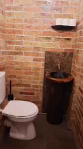 a bathroom with a toilet and a brick wall at Kontra szálláshely in Sándorfalva