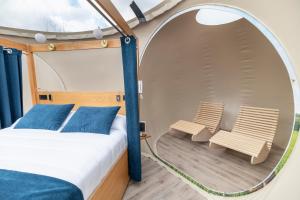 a bed and two chairs in a room with a mirror at Zielo de Levante in Tirig